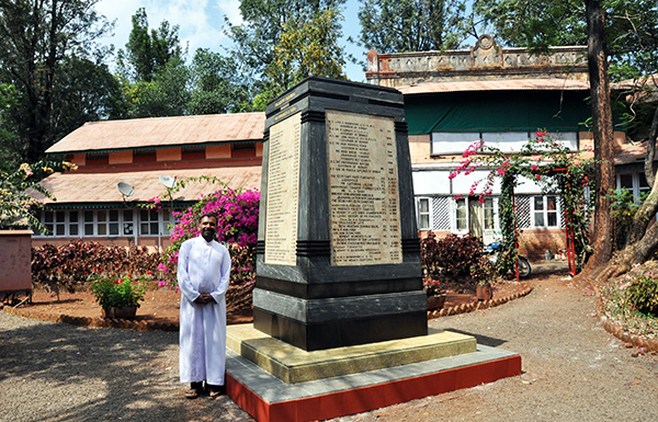 Bel-Air director Fr Tomy K  next to memorial stump